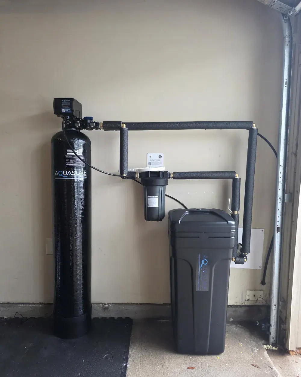 The finished install: AquaSure resin tank, pre-filter and brine tank tied into the wall loop with an insulated bypass.